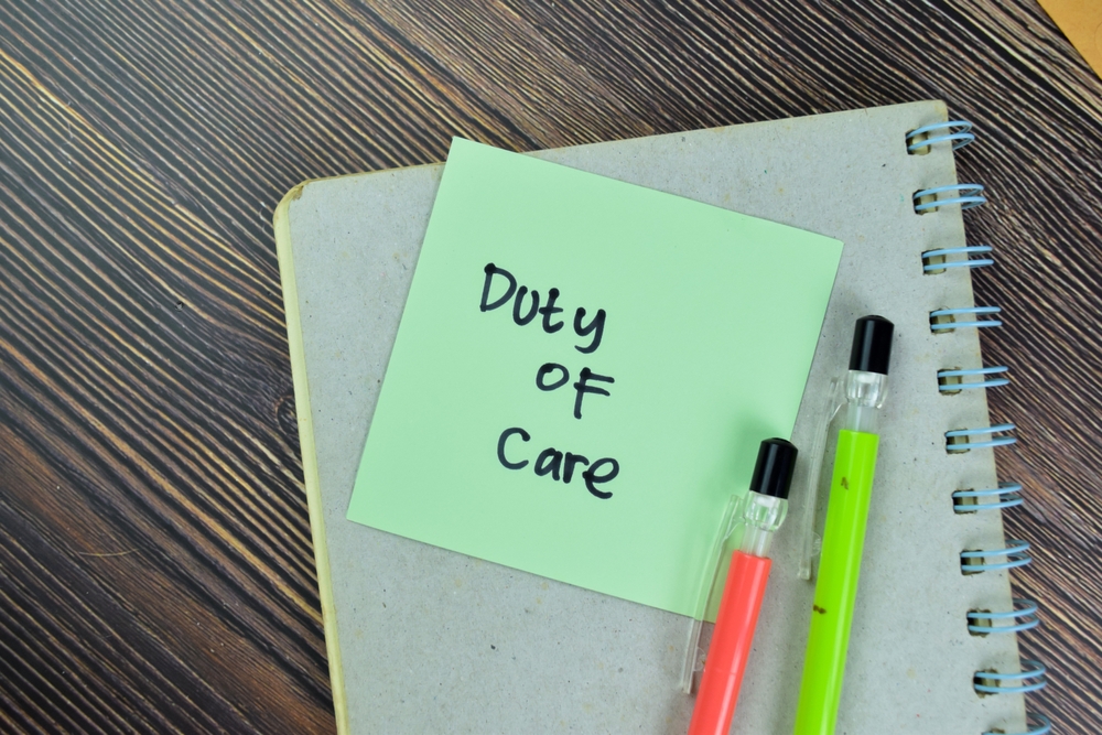 Concept of Duty of Care write on sticky notes isolated on Wooden Table.