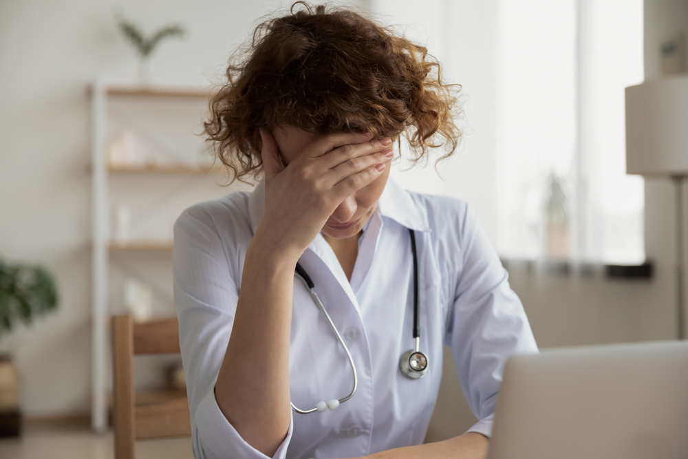 Exhausted depressed young female doctor feels mental burnout at work. Stressed frustrated physician upset about medical failure, healthcare negligence